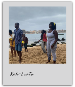 Participants du team building à Dakar sur le thème de Koh-Lanta, prêts pour une épreuve en pleine nature, au bord de l'océan. Légende : Les participants s'organisent avant une épreuve intense, inspirée de Koh-Lanta, dans ce team building unique à Dakar.