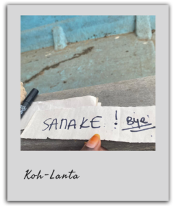 Un participant tenant un papier avec le nom "Sanake", illustrant le moment du vote d’élimination dans le team building à Dakar.