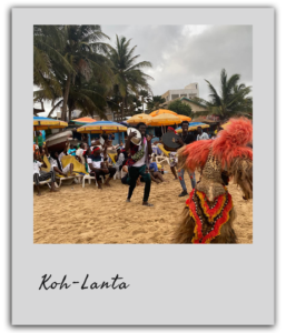Un danseur traditionnel divertissant les participants au team building à Dakar, sur une plage animée.
