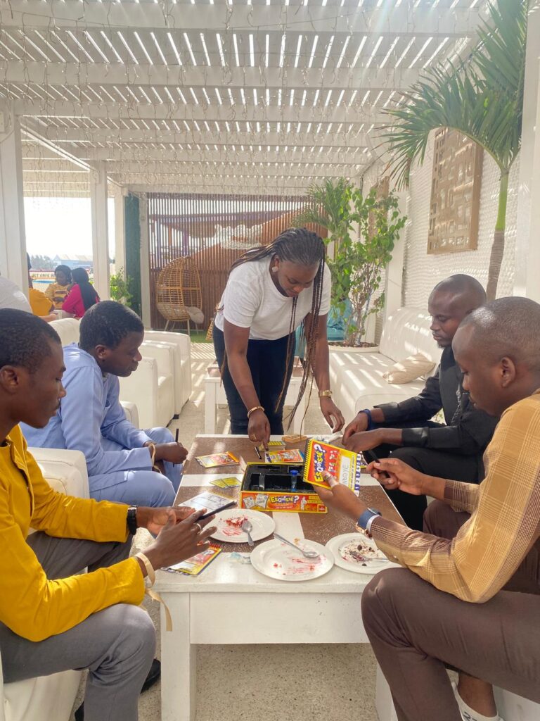 Participants lors d'une session de team building à Dakar autour d'un jeu de société, renforçant la cohésion d'équipe dans un cadre convivial.