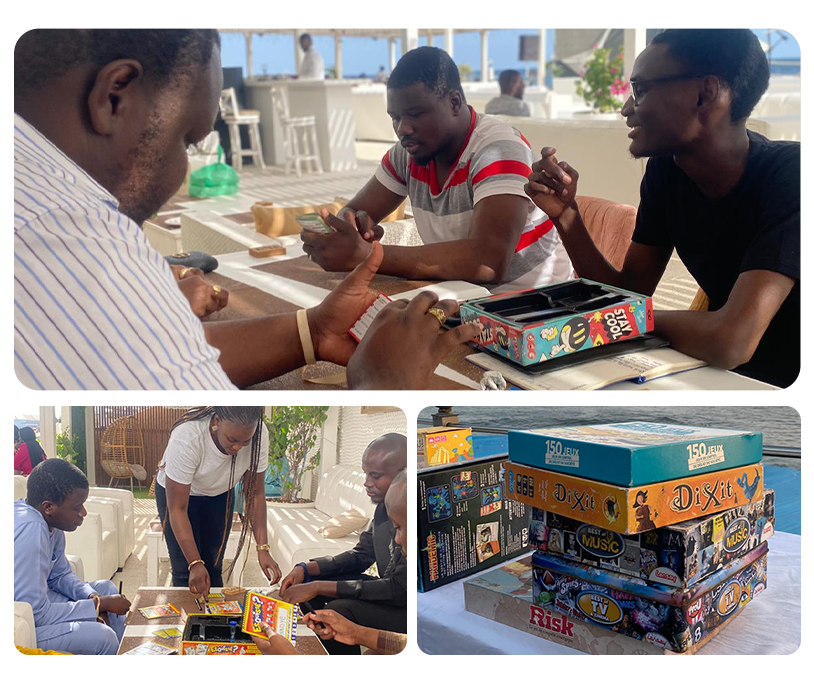 Des collaborateurs jouent à des jeux de société pendant un afterwork à Dakar dans un cadre convivial, entre détente et concentration, avec une vue sur la mer.