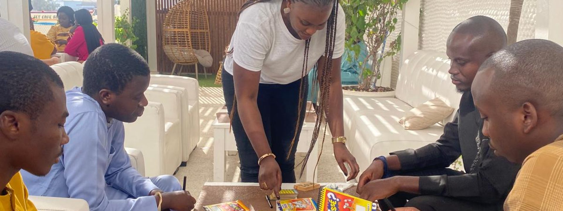 Participants lors d'une session de team building à Dakar autour d'un jeu de société, renforçant la cohésion d'équipe dans un cadre convivial.